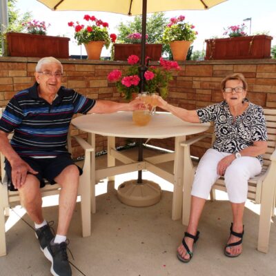 Two seniors sit together while enjoying the outdoors.